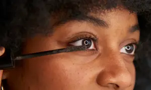 När du vill ta bort vattenfast mascara, använd en mild rengöring. Bilden visar en person som applicerar mascara.