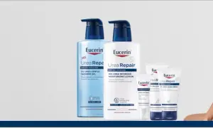 En kvinna ler med en Eucerin UreaRepair-produkt i bakgrunden. Serien innehåller karbamid för ansikte och kropp.