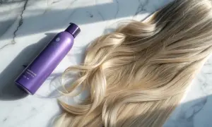 Lila flaska med hårtoning bredvid blont hår. Perfekt för kall brun toning hemma för en fräsch look.