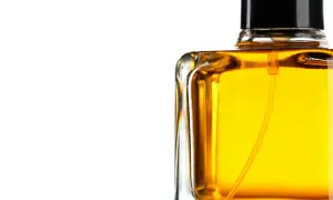 En flaska med gyllene parfym, som lovar en varm och sensuell amber doft.
