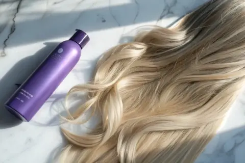 Lila flaska med hårtoning bredvid blont hår. Perfekt för kall brun toning hemma för en fräsch look.