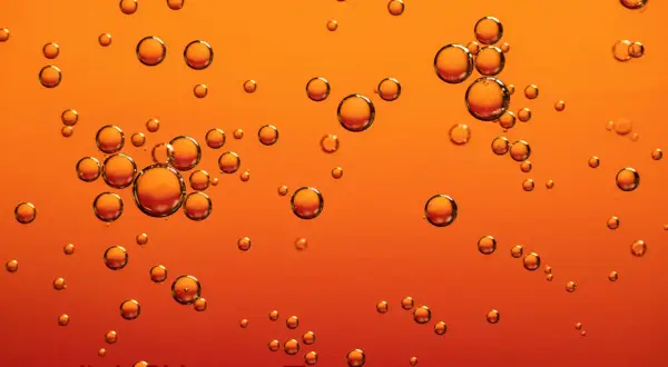 Bubblor i gyllene olja, perfekt för att lugna eksem. Jojobaolja är en naturlig lösning för torr hud.
