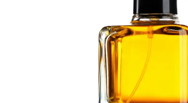 En flaska med gyllene parfym, som lovar en varm och sensuell amber doft.