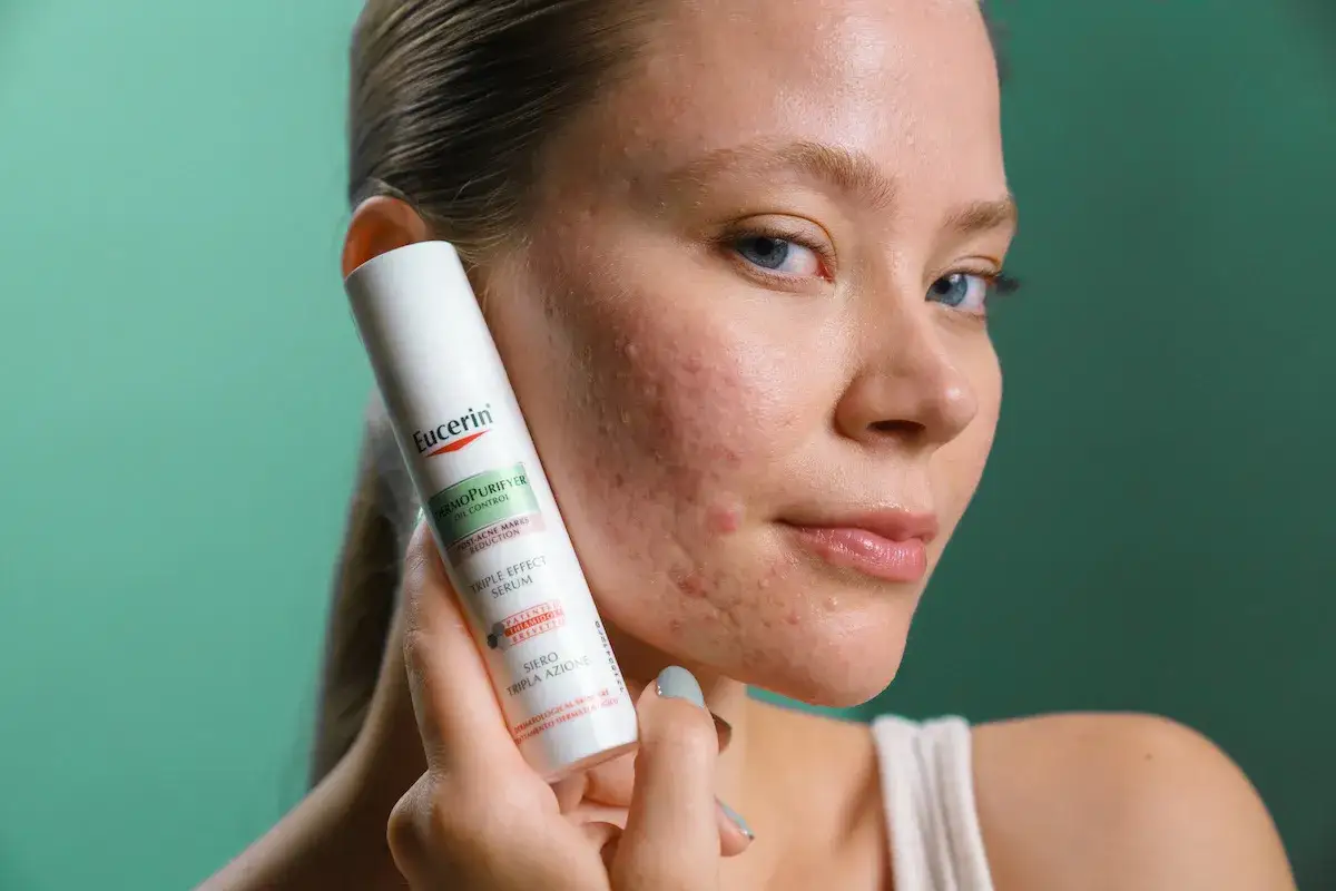 Kvinna med stress finnar h&aring;ller upp en Eucerin-produkt.