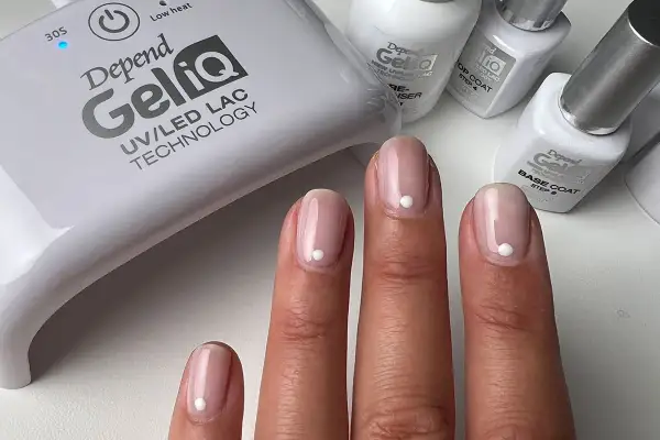 Fina gelenaglar med en vit prick, redo att måla nagellack. Depend GeliQ UV/LED-lampa och produkter syns i bakgrunden.